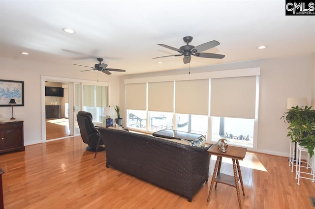 living room with light wood-type flooring and ceiling fan