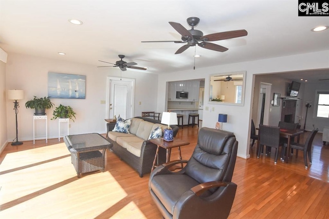 living room featuring wood-type flooring and ceiling fan