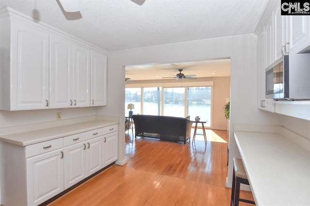 kitchen with white cabinetry, light hardwood / wood-style flooring, and ceiling fan