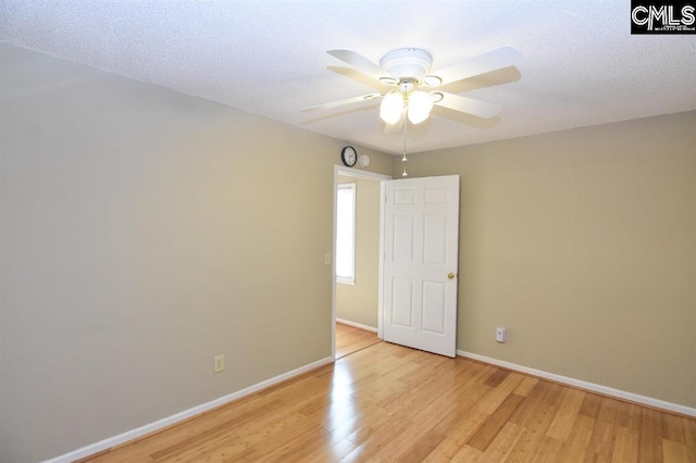 spare room featuring a textured ceiling, light hardwood / wood-style flooring, and ceiling fan