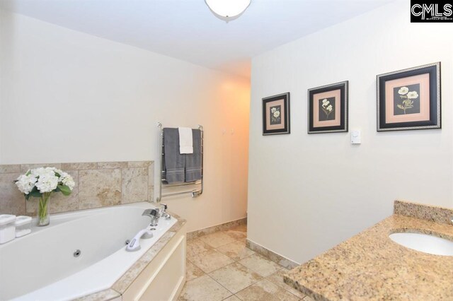 bathroom with tile patterned flooring, a washtub, and sink