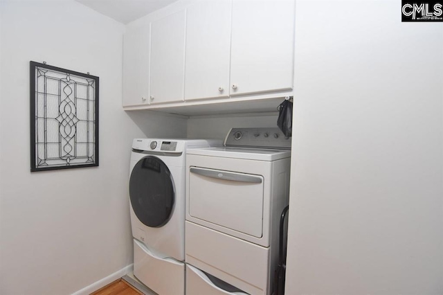 clothes washing area featuring cabinets and independent washer and dryer