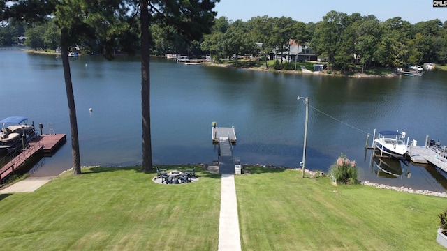 view of dock featuring a water view, a yard, and a fire pit