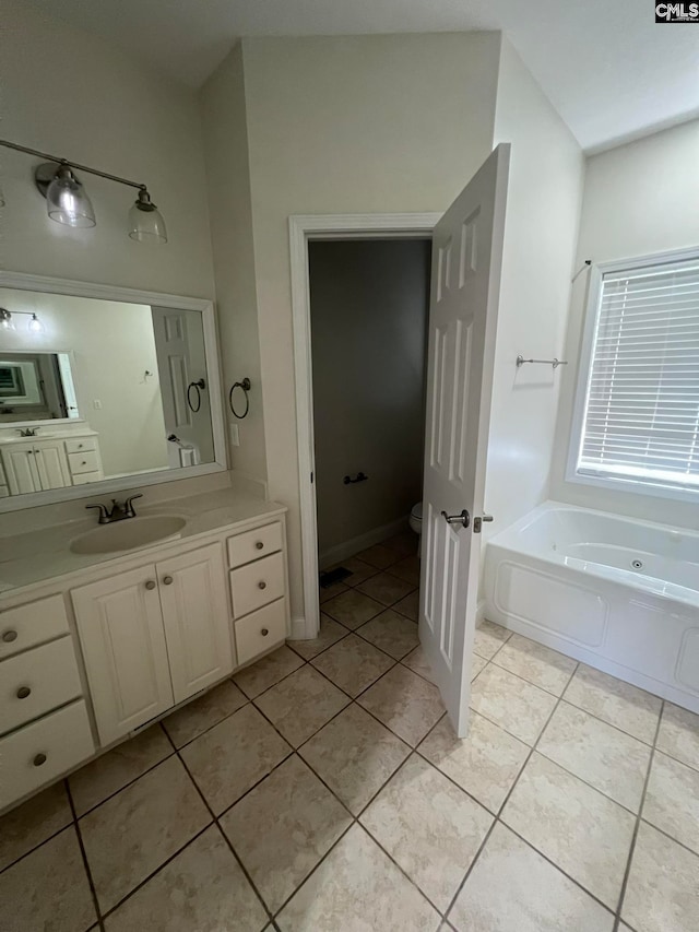 bathroom with a bath, tile patterned floors, toilet, and vanity