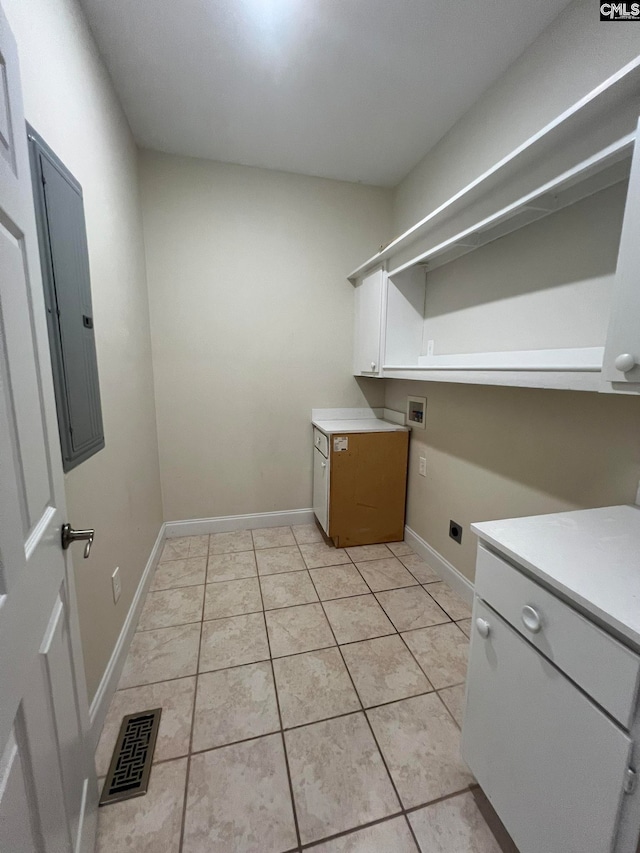 clothes washing area featuring electric panel, hookup for an electric dryer, light tile patterned flooring, washer hookup, and cabinets