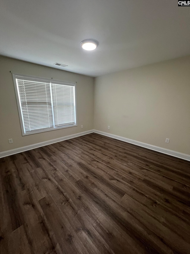 spare room with dark hardwood / wood-style floors