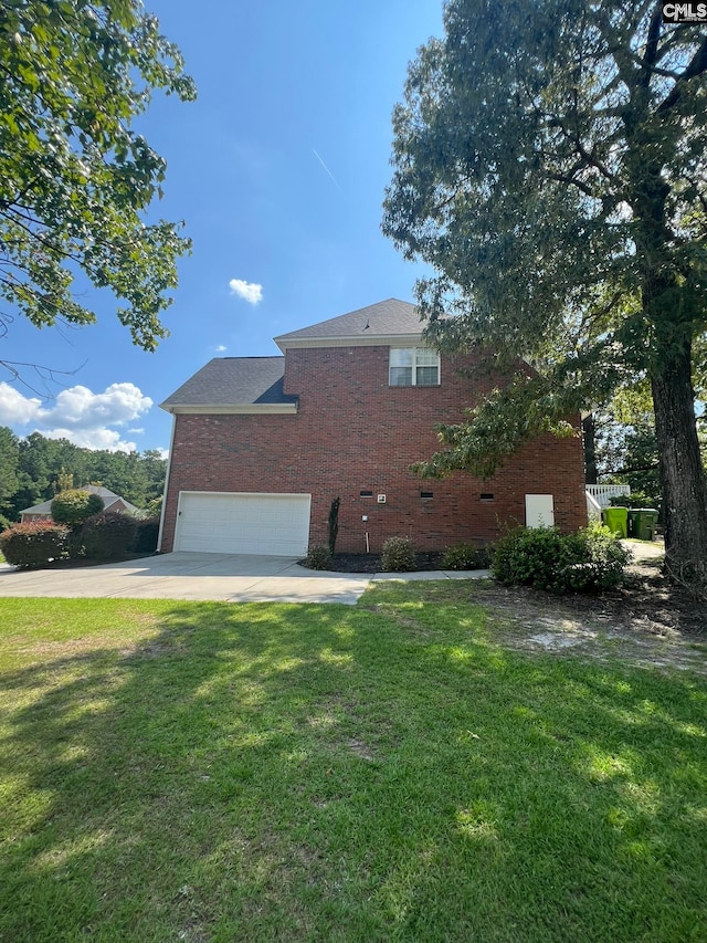 view of side of home with a lawn and a garage