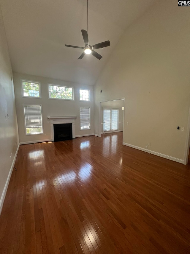 unfurnished living room featuring dark hardwood / wood-style flooring, high vaulted ceiling, and ceiling fan