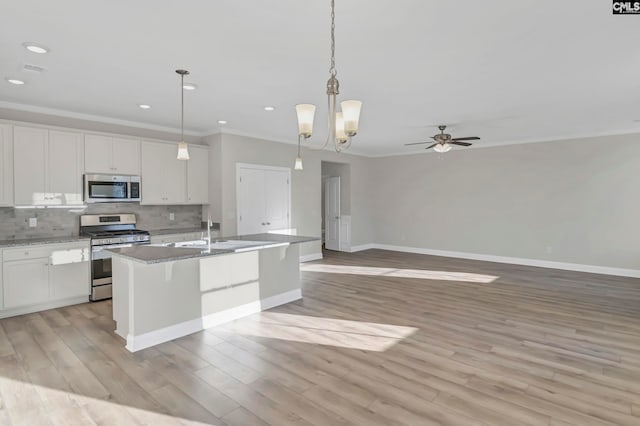 kitchen with an island with sink, light hardwood / wood-style flooring, stainless steel appliances, and white cabinetry