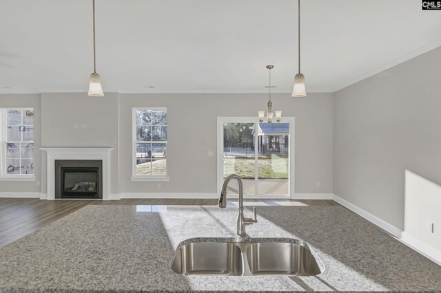 kitchen with a chandelier, hardwood / wood-style flooring, decorative light fixtures, and sink