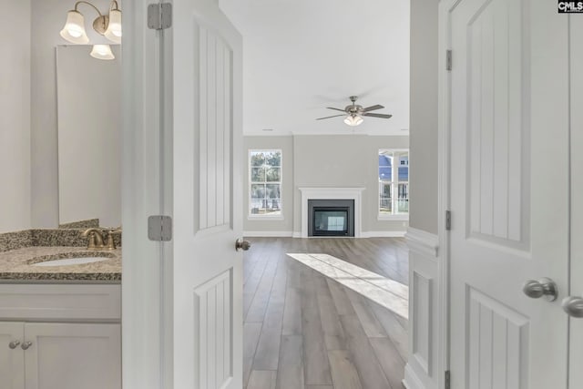 hall with light hardwood / wood-style flooring and sink