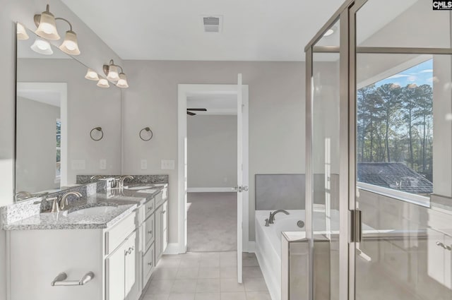 bathroom with ceiling fan with notable chandelier, vanity, a bathing tub, and tile patterned floors