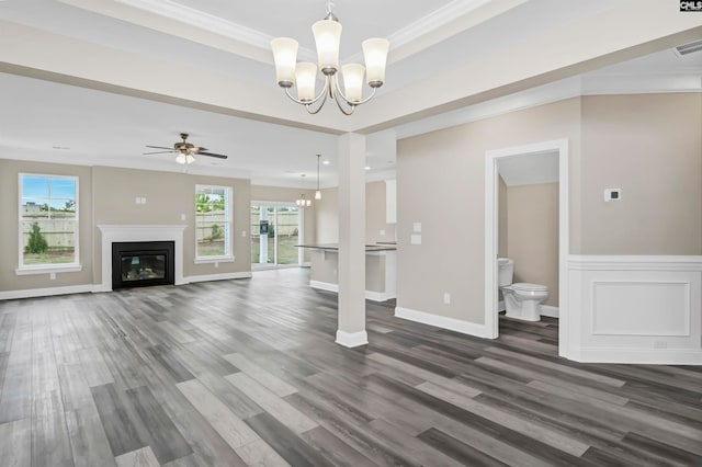 unfurnished living room featuring a wealth of natural light, ornamental molding, dark hardwood / wood-style floors, and ceiling fan with notable chandelier