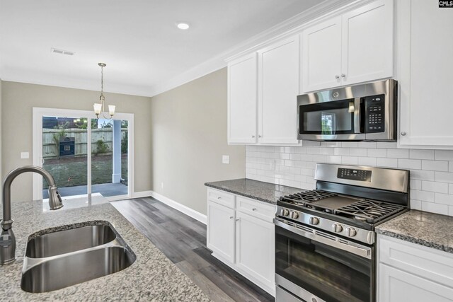 kitchen with stone countertops, white cabinetry, dark hardwood / wood-style flooring, sink, and appliances with stainless steel finishes