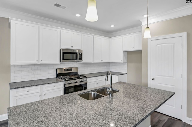 kitchen with dark stone countertops, stainless steel appliances, decorative backsplash, and sink