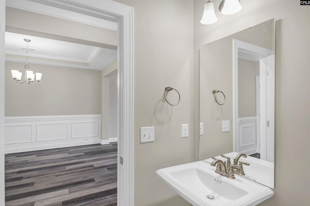 bathroom with hardwood / wood-style flooring, sink, and a notable chandelier