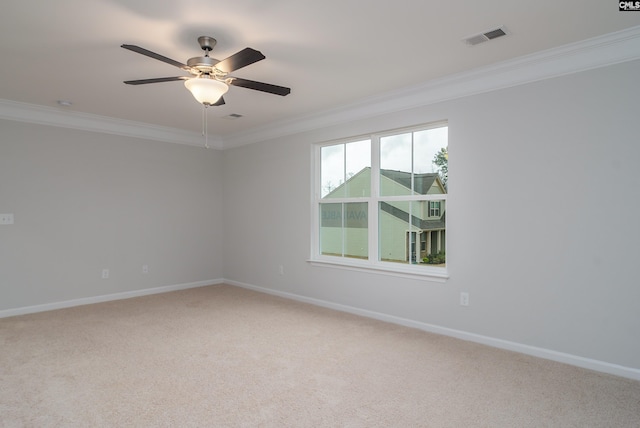 carpeted spare room with ceiling fan and ornamental molding