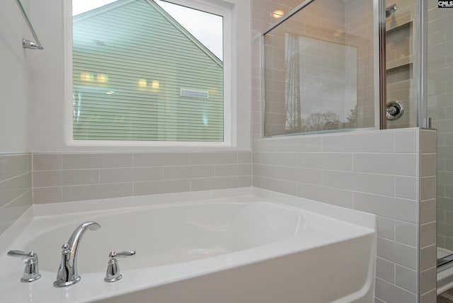 bathroom featuring shower with separate bathtub