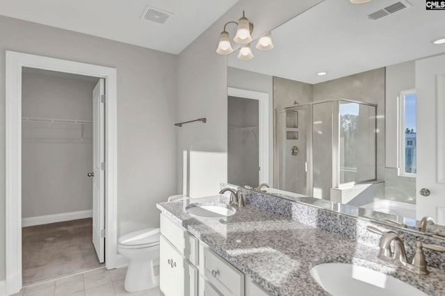 bathroom with tile patterned floors, walk in shower, vanity, a notable chandelier, and toilet