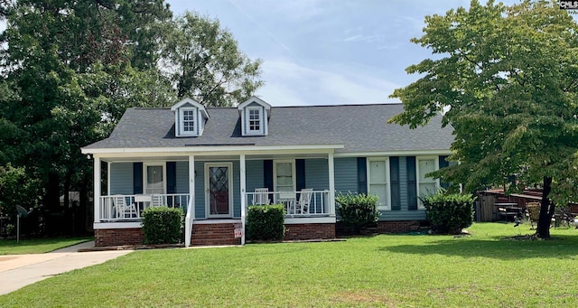 new england style home with a front yard and covered porch