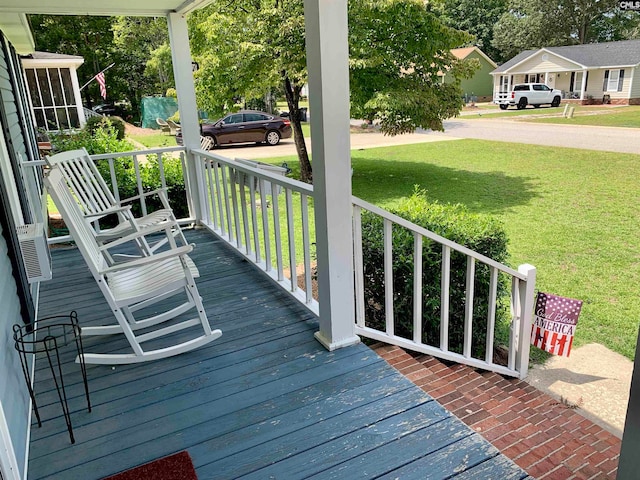 wooden terrace featuring a yard and a porch