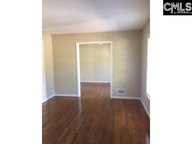 unfurnished room with dark wood-type flooring