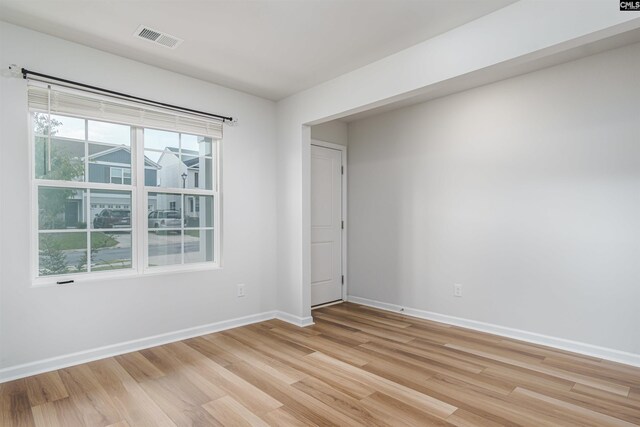 spare room featuring plenty of natural light and light hardwood / wood-style flooring