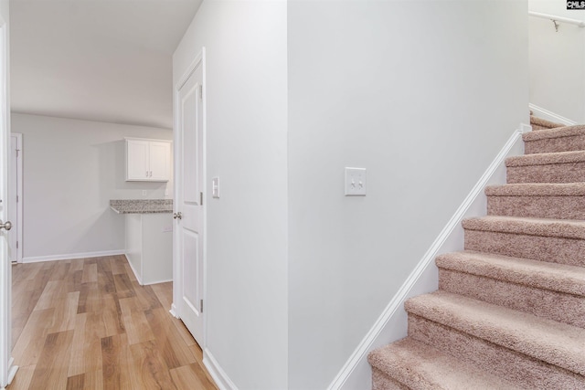 stairway with hardwood / wood-style floors