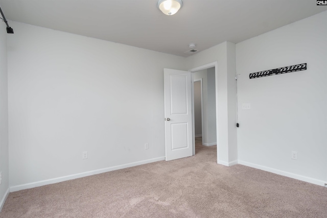 spare room featuring light colored carpet