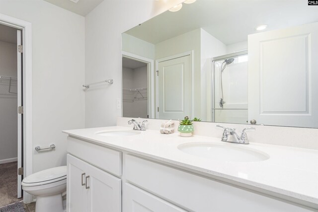 bathroom featuring walk in shower, toilet, and vanity