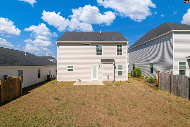 back of house with a patio area and a lawn