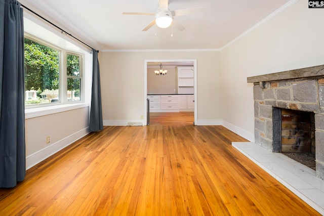 unfurnished living room featuring ceiling fan with notable chandelier, hardwood / wood-style flooring, a fireplace, and crown molding