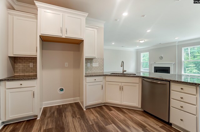 kitchen featuring dark stone countertops, dishwasher, plenty of natural light, and sink