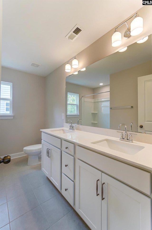 bathroom with tile patterned floors, toilet, an enclosed shower, and vanity