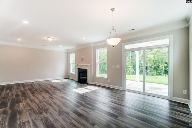 unfurnished living room with ornamental molding, dark hardwood / wood-style flooring, and a healthy amount of sunlight