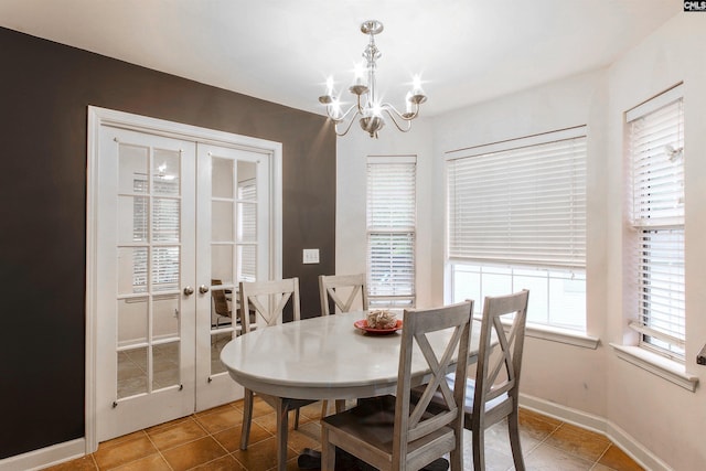 tiled dining area with a chandelier and french doors