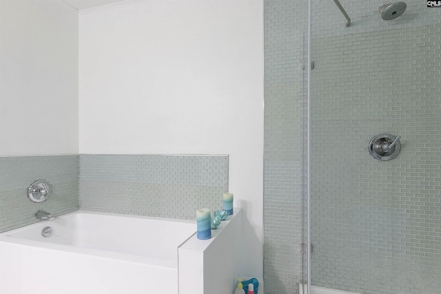 bathroom featuring ornamental molding and separate shower and tub