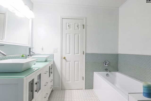 bathroom with a tub to relax in, ornamental molding, vanity, and tile patterned floors