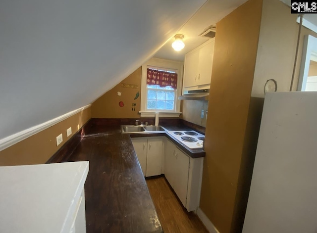 kitchen with under cabinet range hood, vaulted ceiling, wood finished floors, white appliances, and a sink