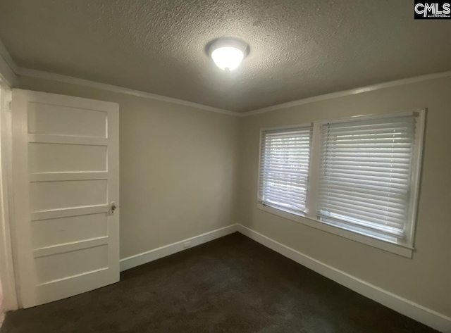 empty room with dark carpet, a textured ceiling, baseboards, and ornamental molding