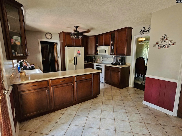 kitchen with white appliances, light tile patterned floors, kitchen peninsula, sink, and ceiling fan