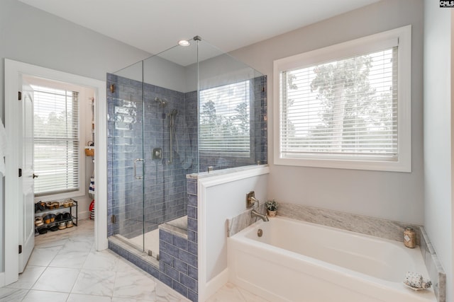 bathroom featuring a healthy amount of sunlight and shower with separate bathtub