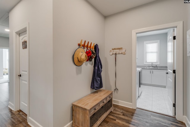 interior space with dark wood-type flooring, washer and clothes dryer, and sink