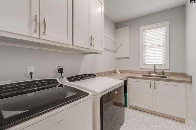 clothes washing area featuring separate washer and dryer, cabinets, and sink