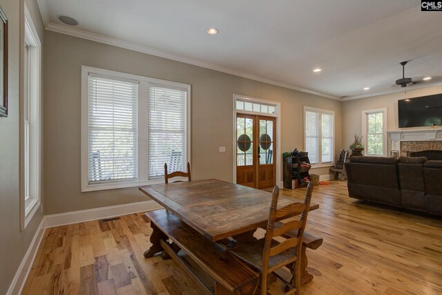 dining room with ceiling fan, ornamental molding, and light wood-type flooring