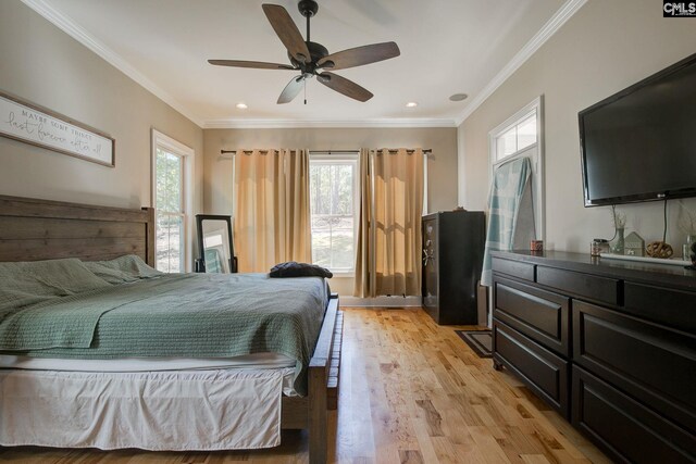 bedroom with light hardwood / wood-style flooring, ceiling fan, and ornamental molding