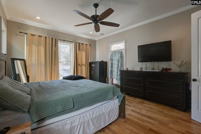 bedroom with ceiling fan, ornamental molding, and light wood-type flooring