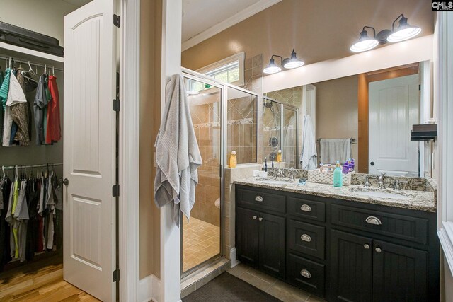 bathroom with ornamental molding, vanity, hardwood / wood-style floors, and walk in shower