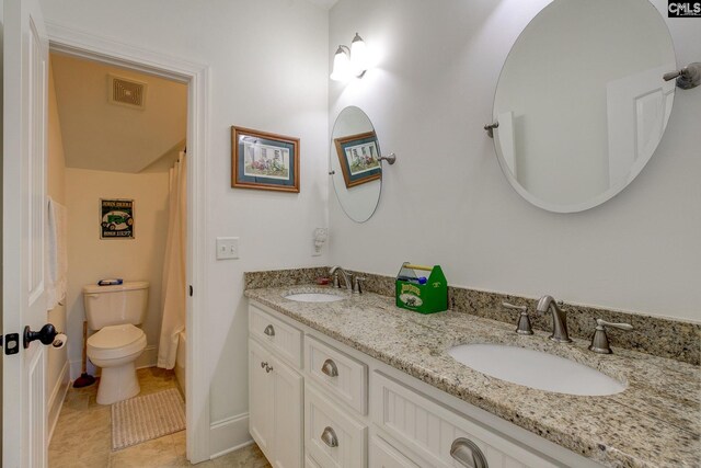 bathroom with tile patterned flooring, vanity, and toilet