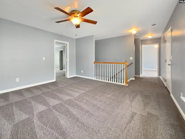 unfurnished room featuring a ceiling fan, visible vents, baseboards, and carpet floors